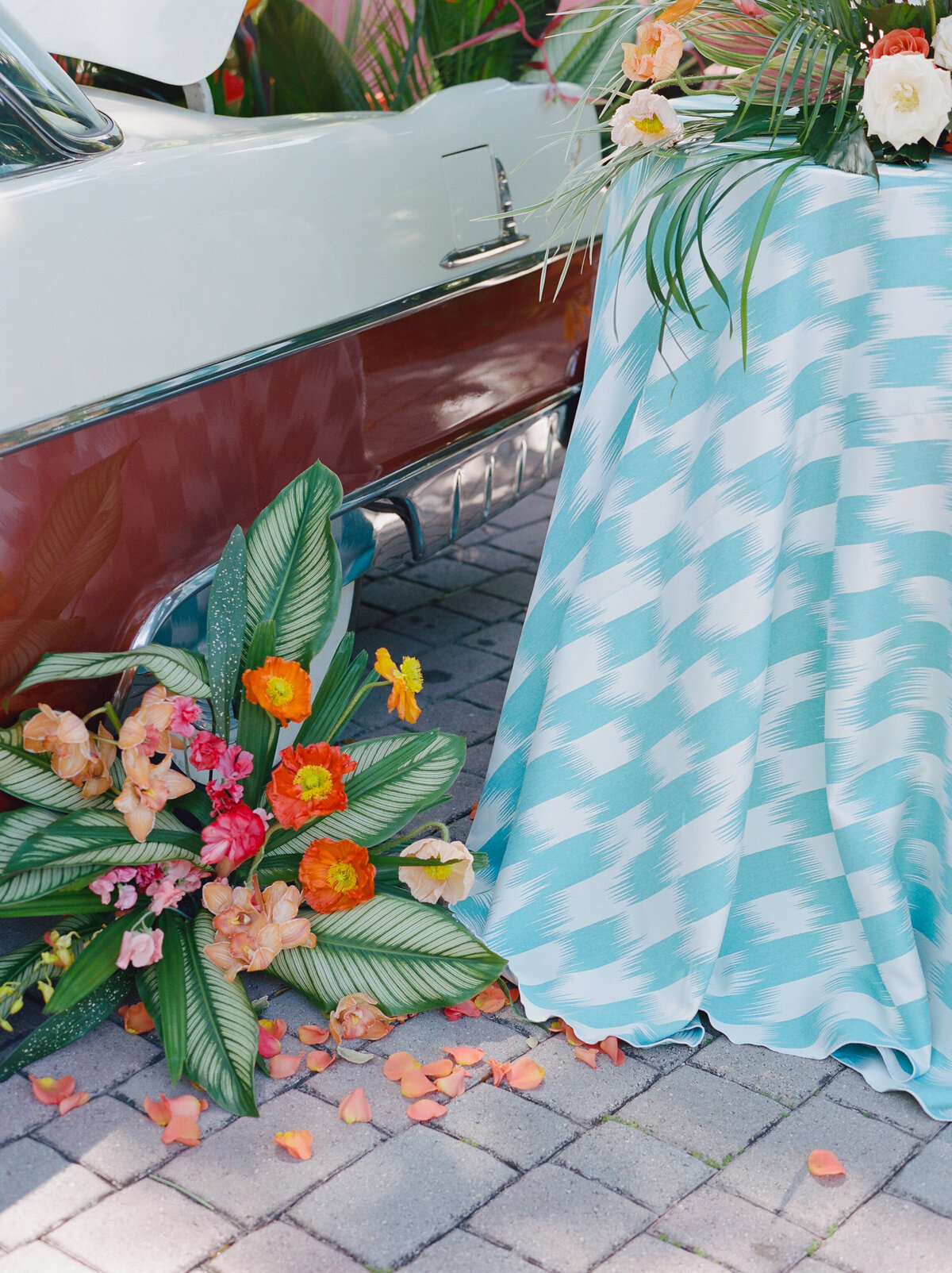 More flowers on the ground beside the car.