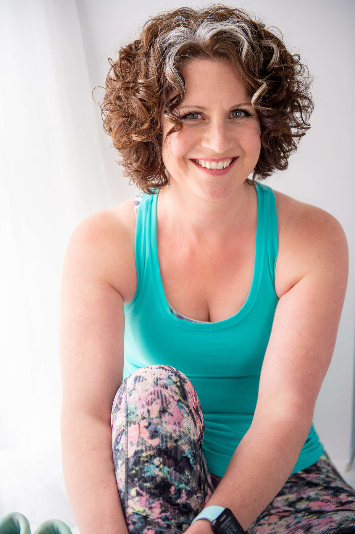 Ottawa branding photography of a smiling woman in a turquoise tank top and patterned leggings.  Captured by JEMMAN Photography COMMERCIAL