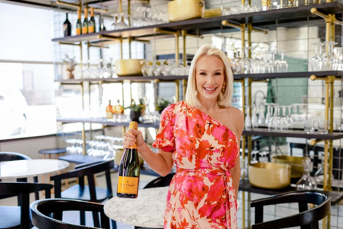 Maryland realtor, Kelly Schuit, holds a bottle of champagne