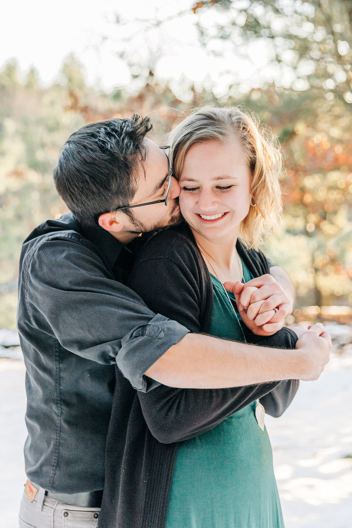 guy hugging girl from behind and kissing her on the cheek