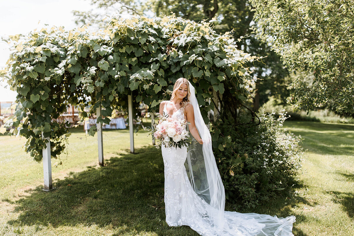 bridal portrait outdoors undre grapevine walkway in upstate new york