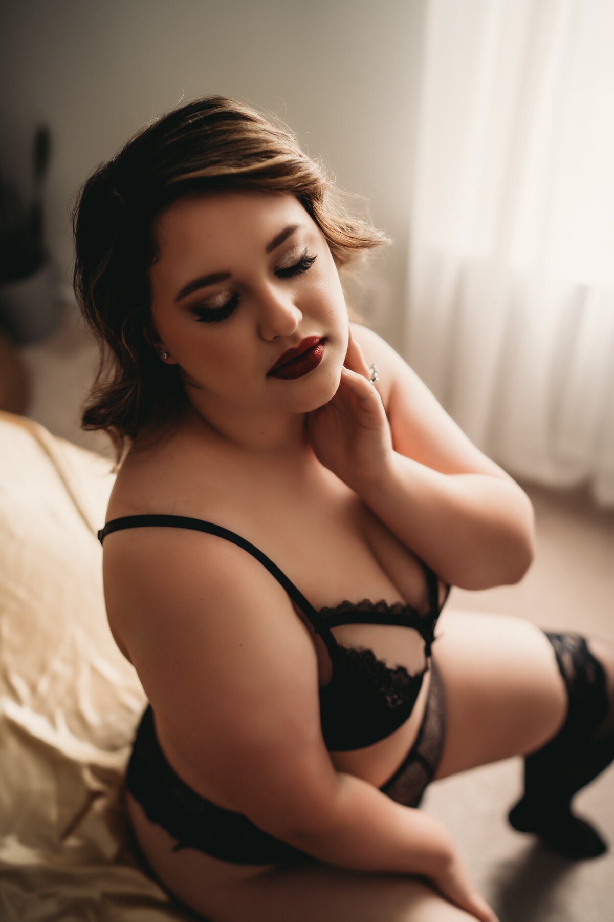 Lady sitting on bed in lingerie