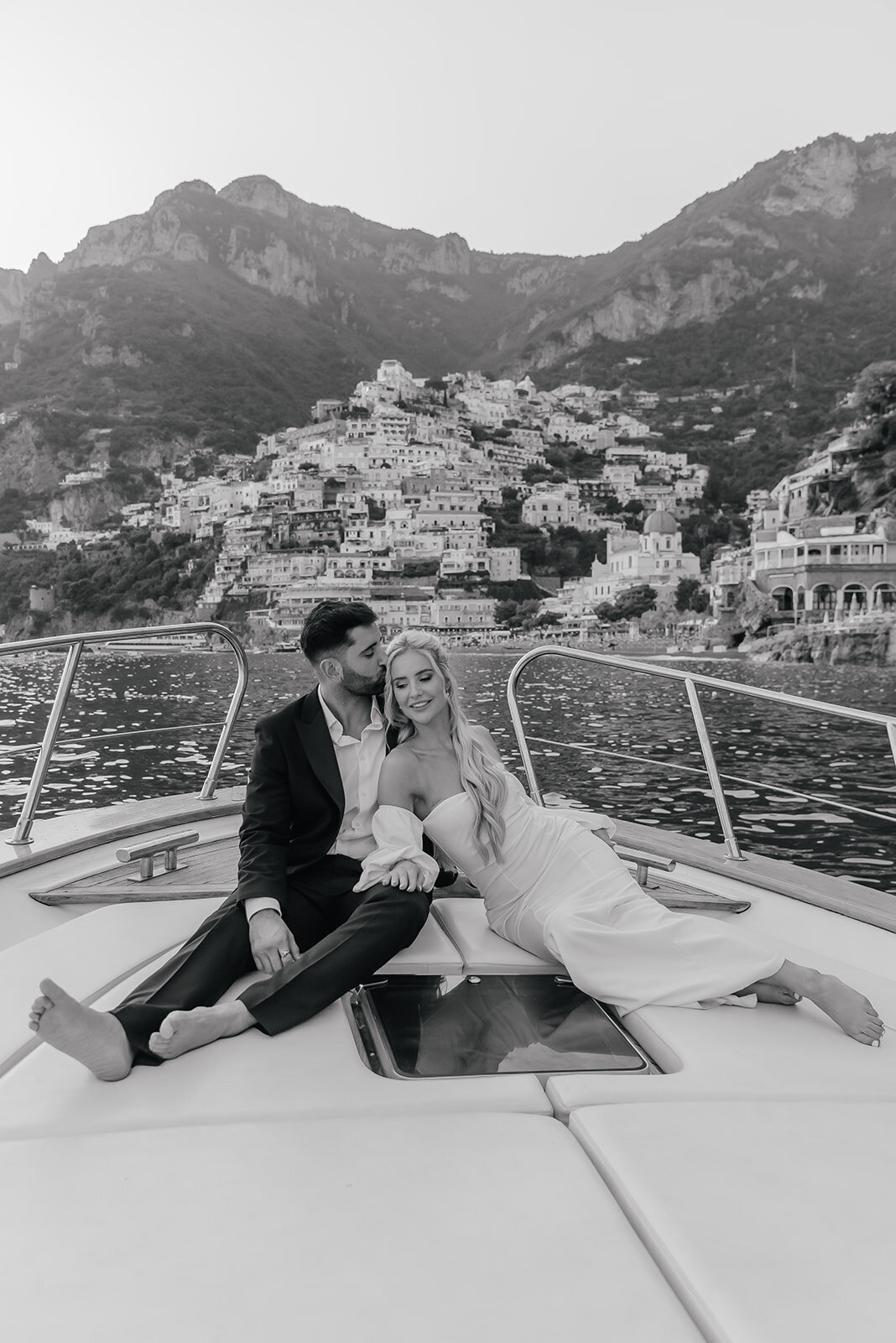 Bride and Groom cuddle up on a boat overlooking Positano Island