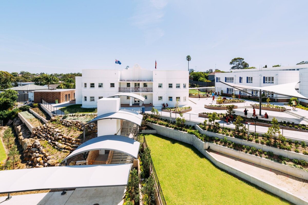 Wide view of Marist Catholic College South Hurstville campus exterior, showing modern white school building and landscaped courtyard built by Serlana Construction.
