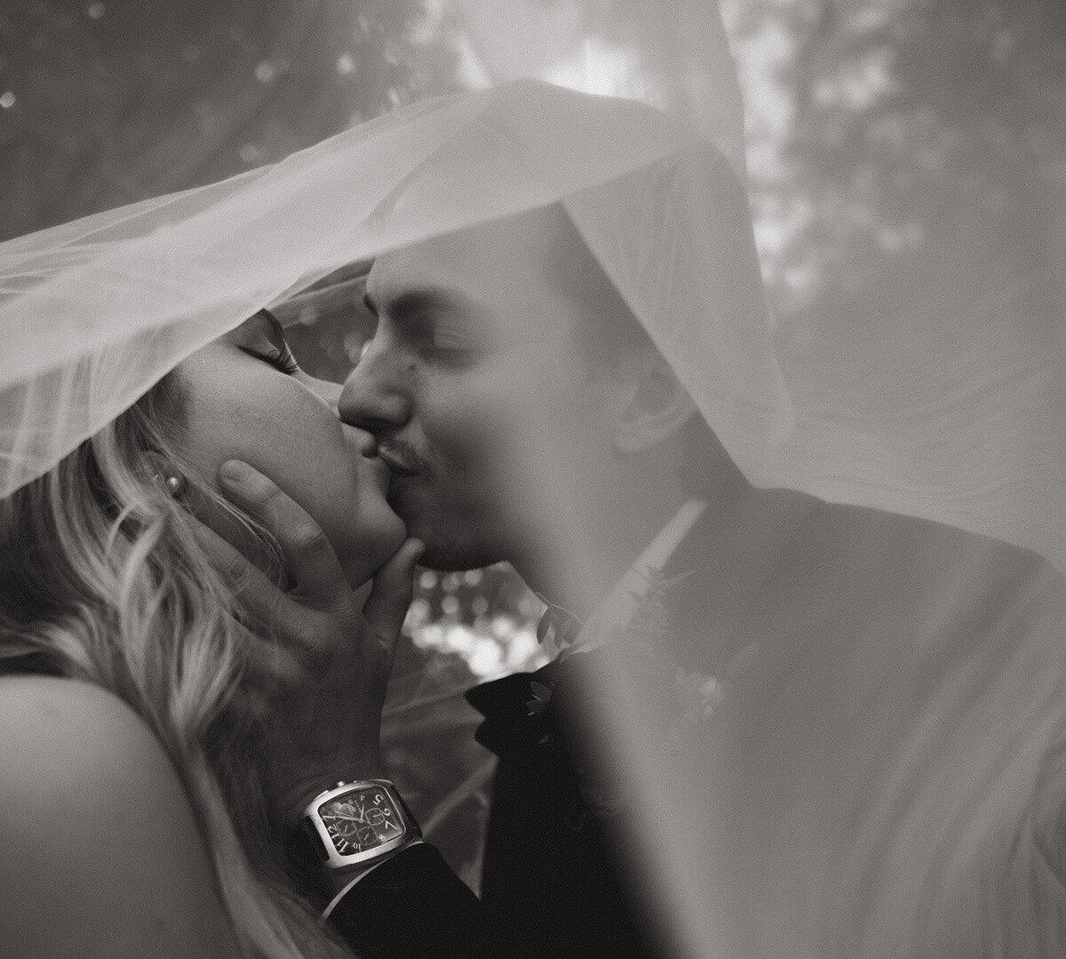 Bride and groom sharing a kiss under the brides veil