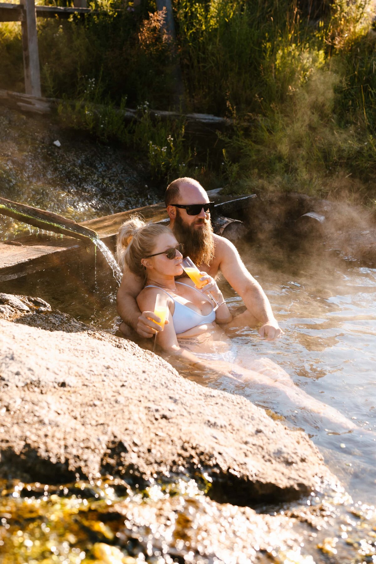 A couple enjoying an Idaho hot spring on the morning of their elopement