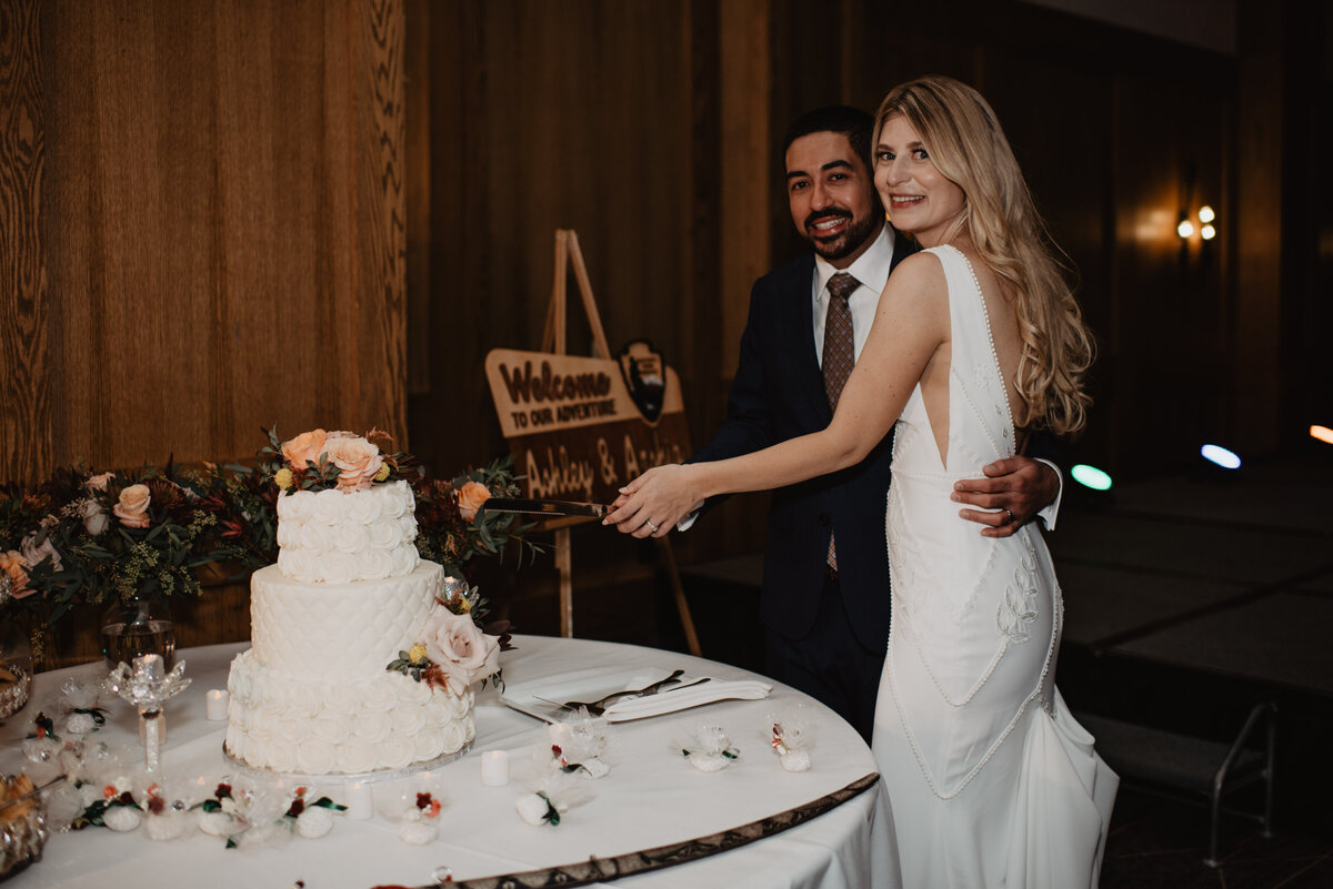 Photographers Jackson Hole capture bride and groom cutting cake