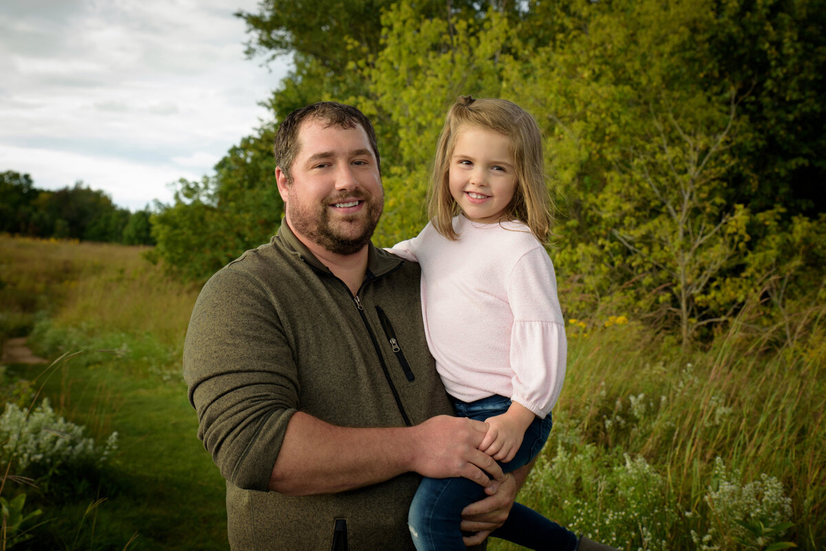 Father and daughter portrait in a long grassy field at Fonferek Glen County Park near Green Bay, Wisconsin.