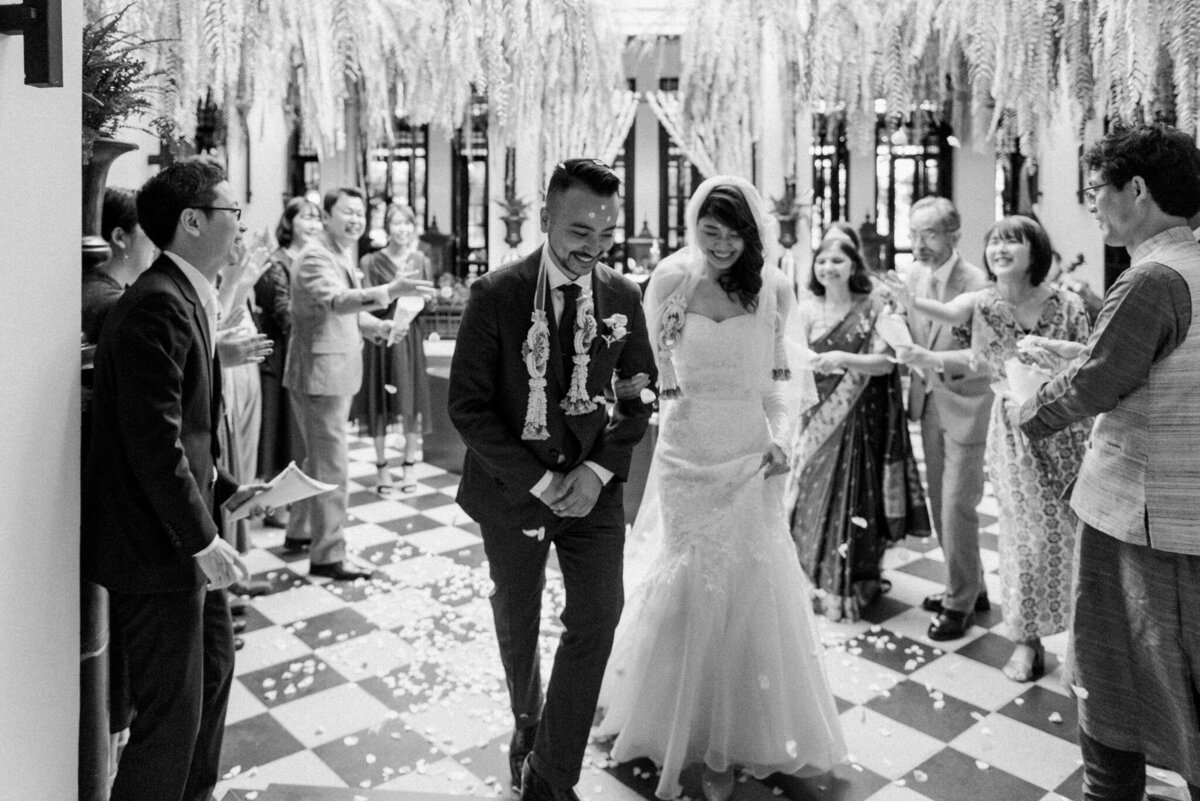 Bride and groom exiting their incredible indoor wedding ceremony captured by Pam Kriangkum Photography, fine art, classic wedding photographer in Edmonton, Alberta. Featured on the Bronte Bride Vendor Guide.
