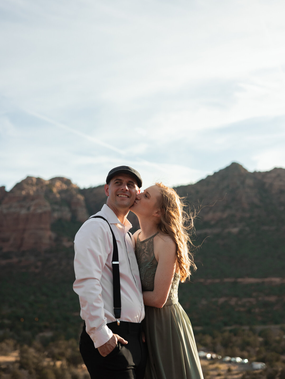 Couple standing against red rock backdrop during Sedona engagement session