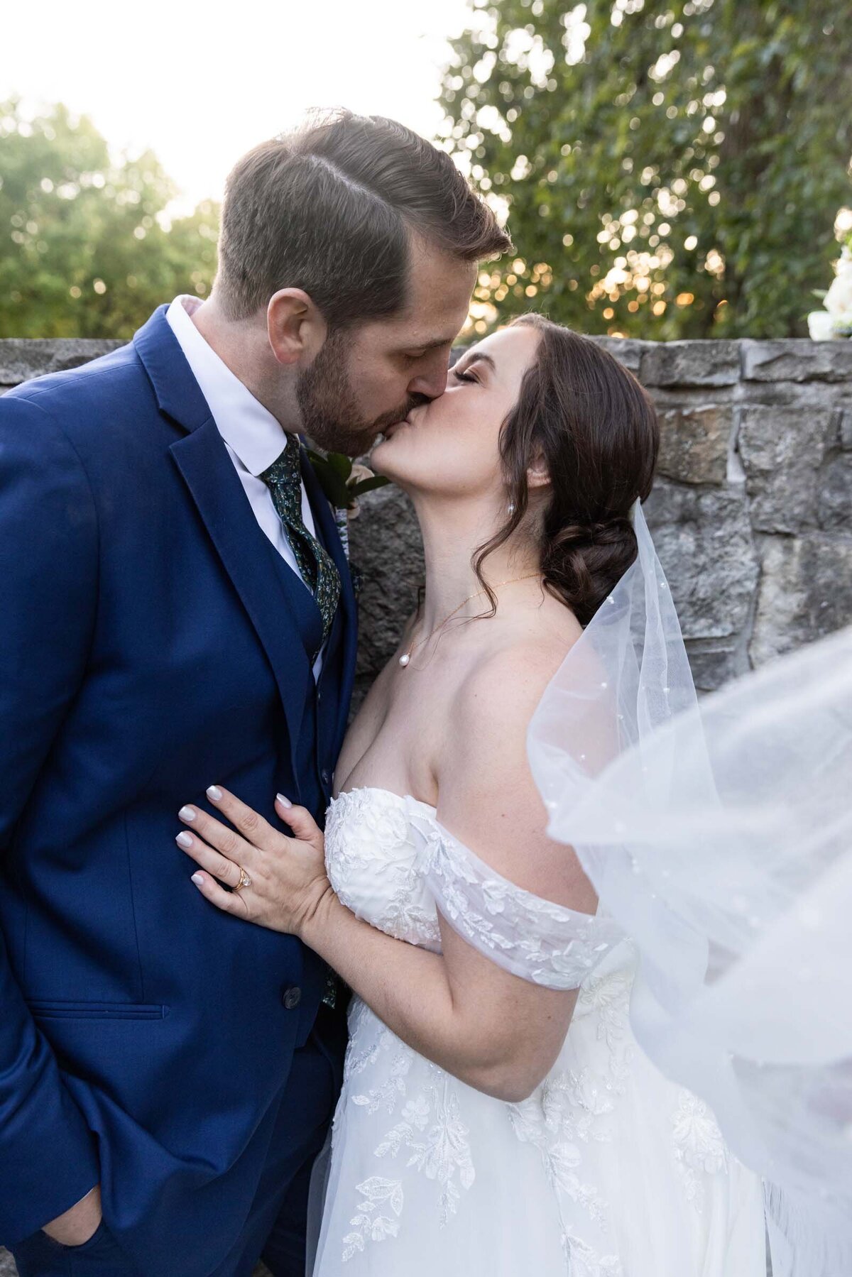 bride-kissing-groom-veil-flowing-golden-hour