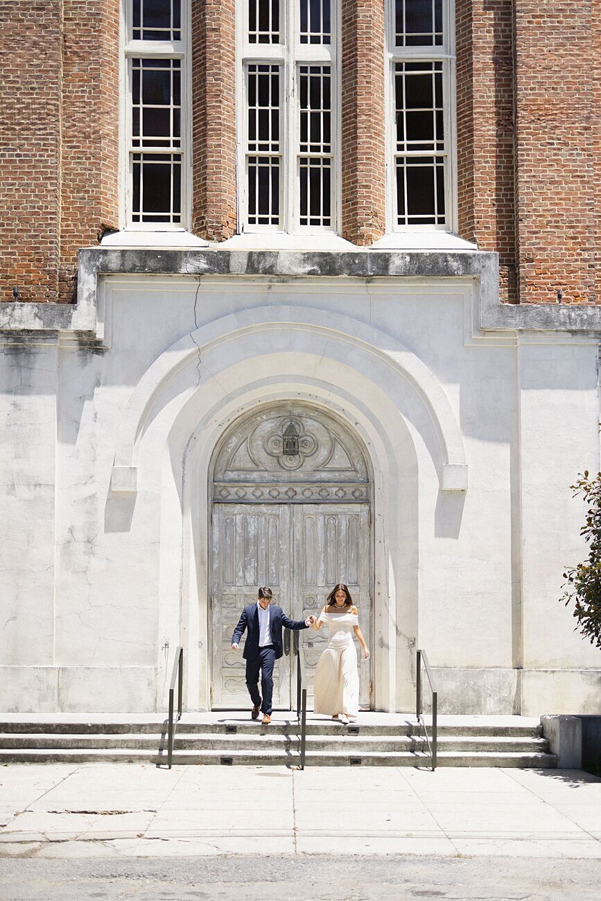 girl and guy walking down steps outside of the chapel of hotel peter and paul in new orleans
