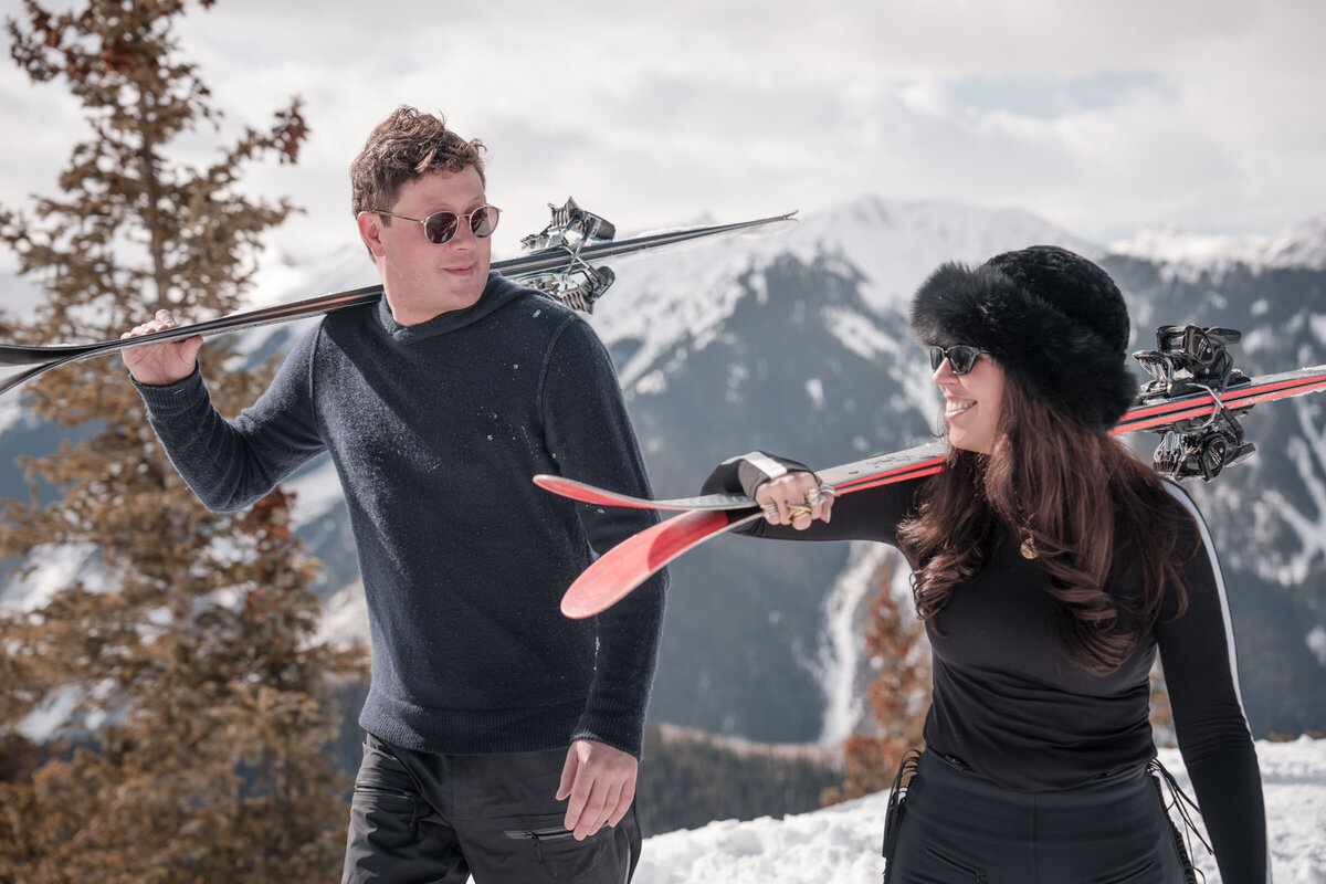Couple walking beside a wooden fence during a fall engagement session in Snowmass