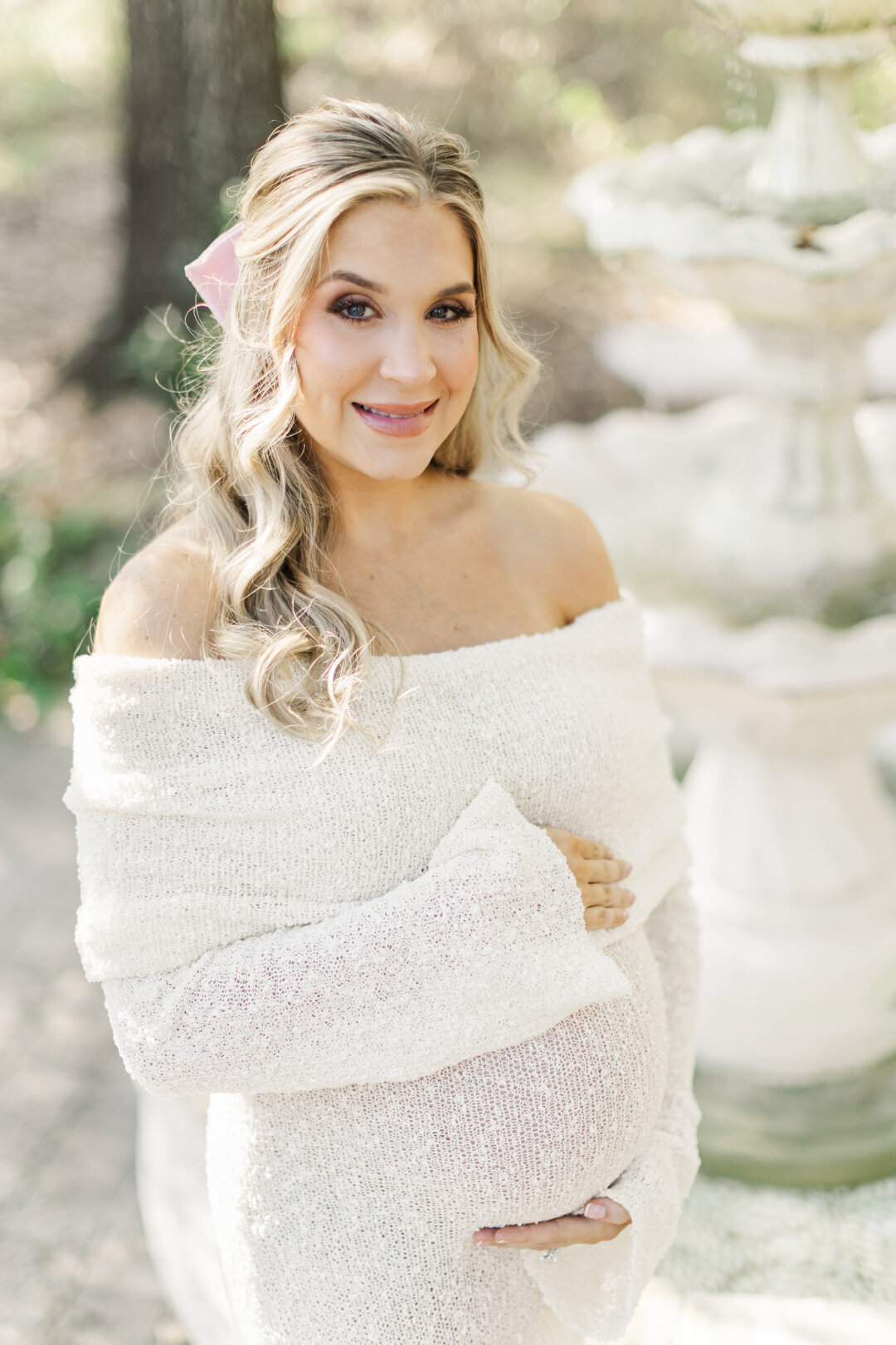mom holds belly smiling at camera for houston maternity photo session