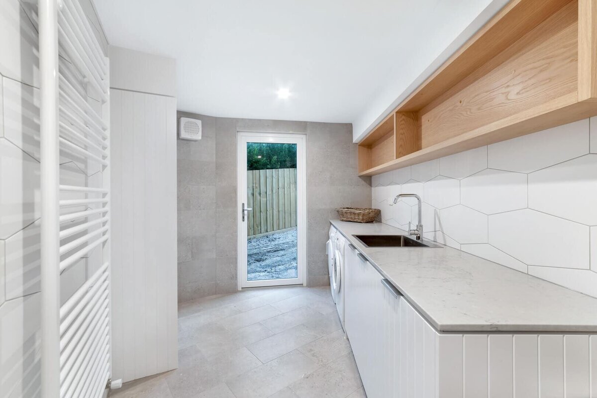 Utility room with sink and grey tiles