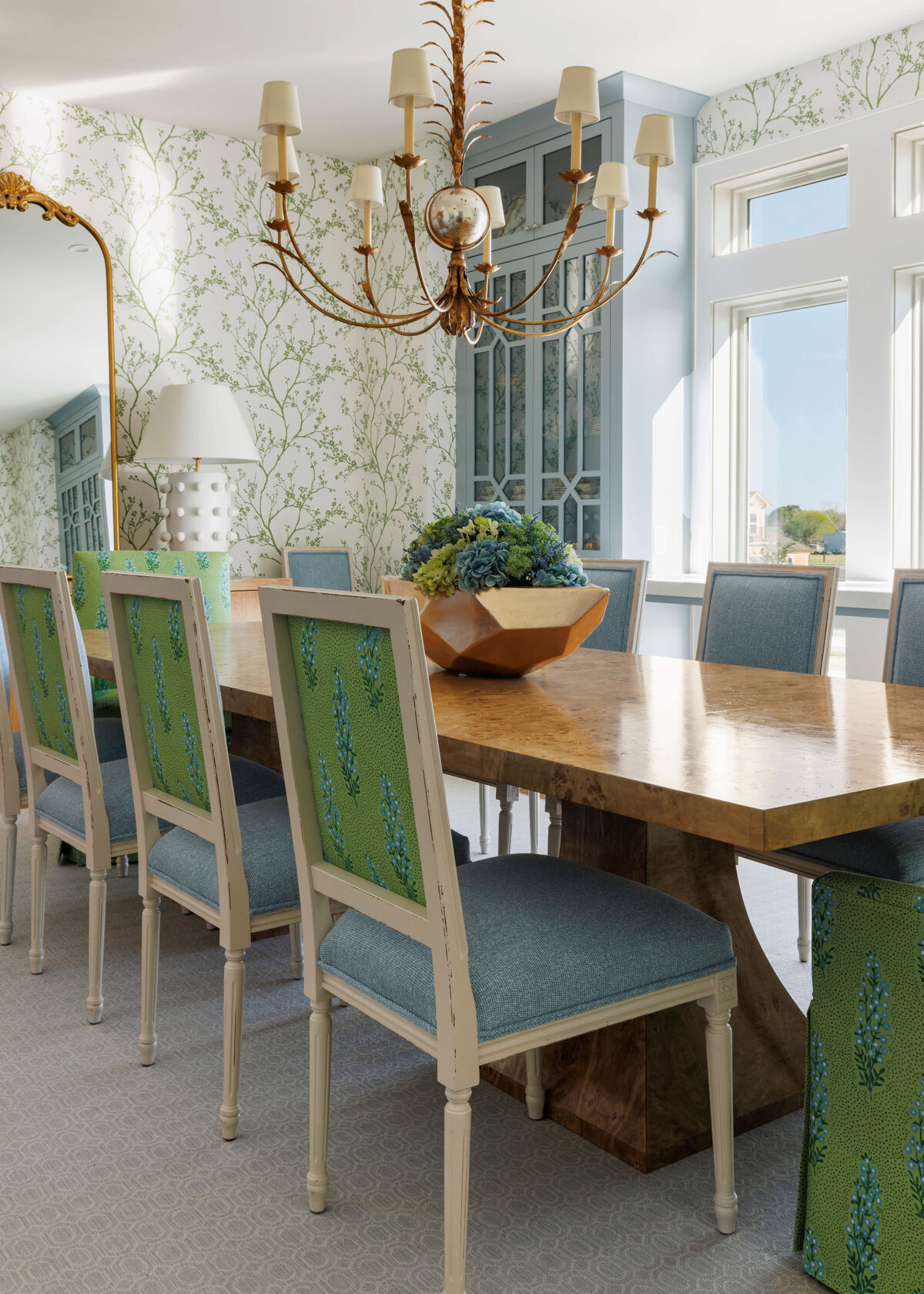 oyster creek studios lighthouse on the ivory chairs with blue and green cushions around a wooden dining room table with geometric centerpiece in dining room
