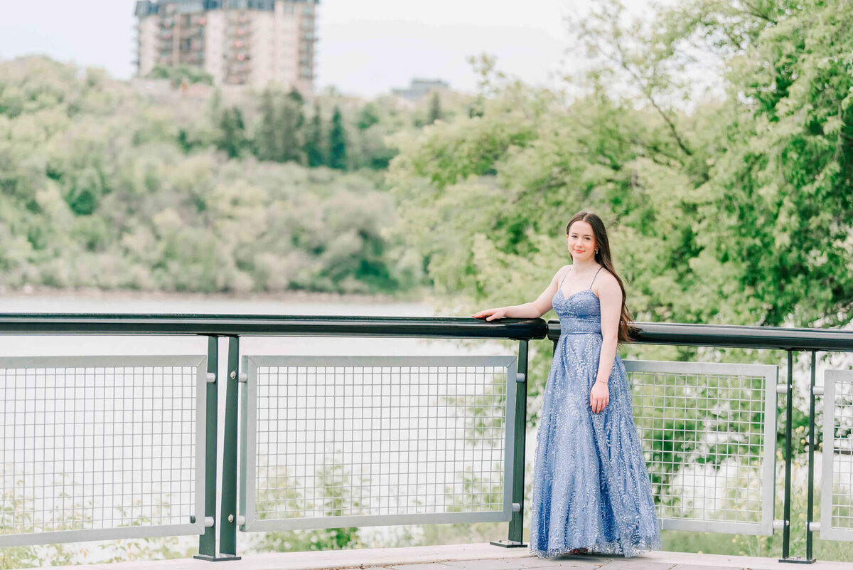 A full length photo of a girl standing by the river. 
