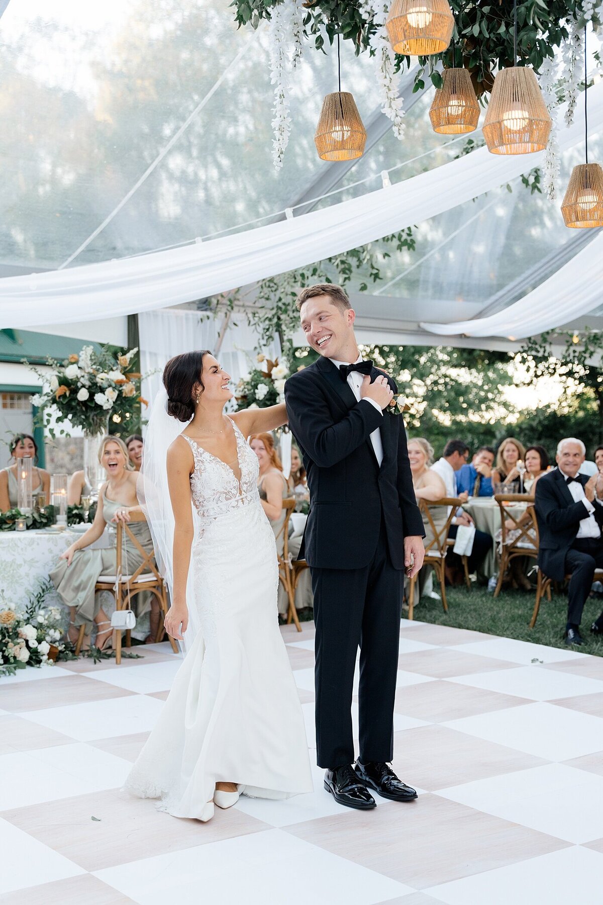 bride and groom dance together on a temporary dance floor in a white tent for their backyard wedding photographed by Columbus wedding  photographer