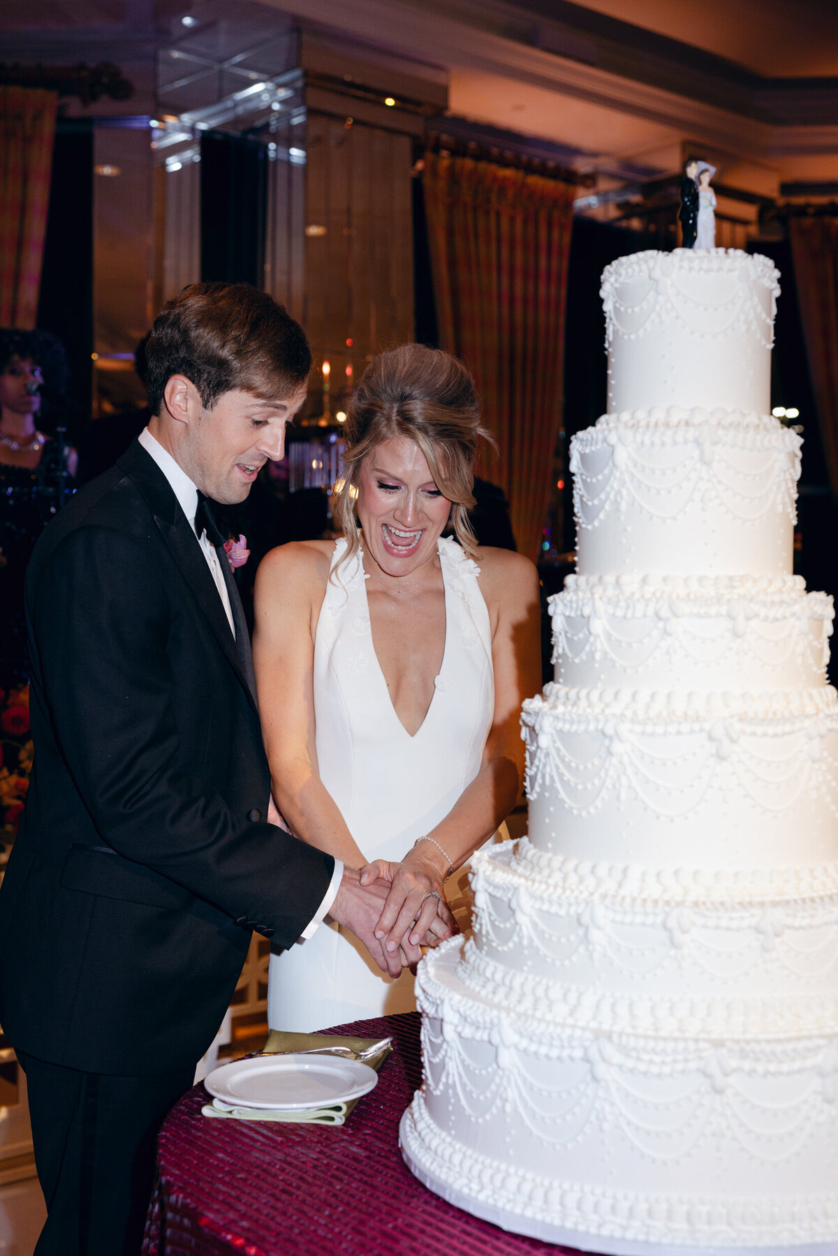 A wedding day photo of the bride and groom cutting their cake during their wedding reception