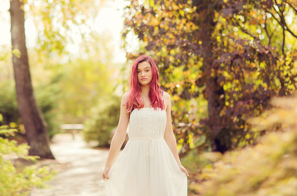 A teenage girl with red hair and a white flowing dress at The Japanese Garden.