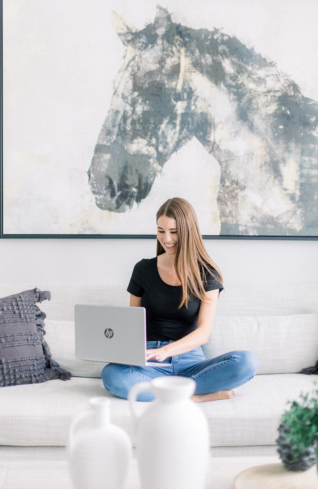 Branding photo of brunette woman working from laptop on the couch