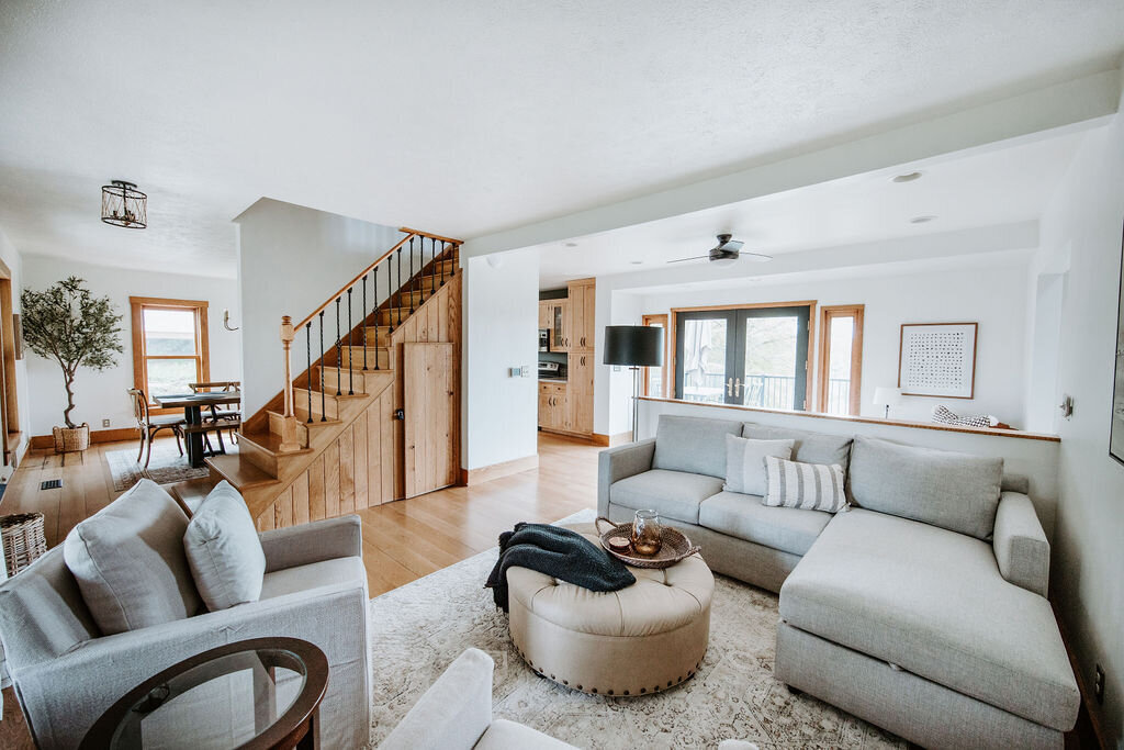 a crate and barrel sectional sofa with neutral decor in the living room of the modern farmhouse overnight accommodations at Willowbrook wedding venue