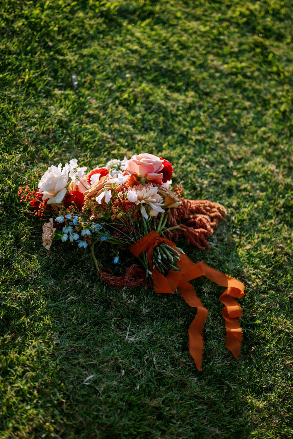 rust-red-bouquet-lying-in-green-grass