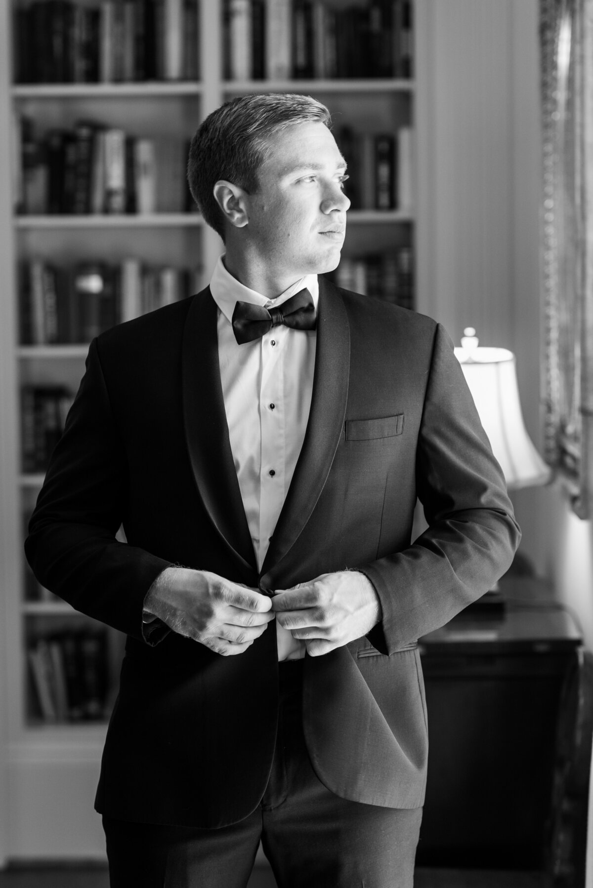 groom posing by window