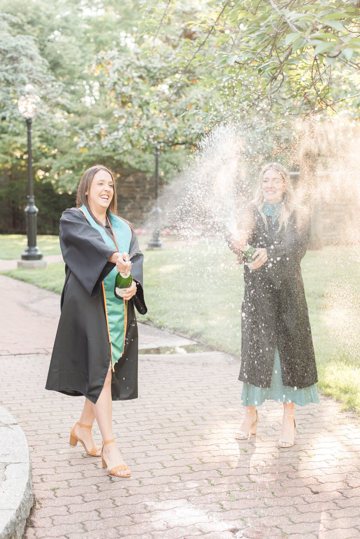 graduate sisters splashing champagne