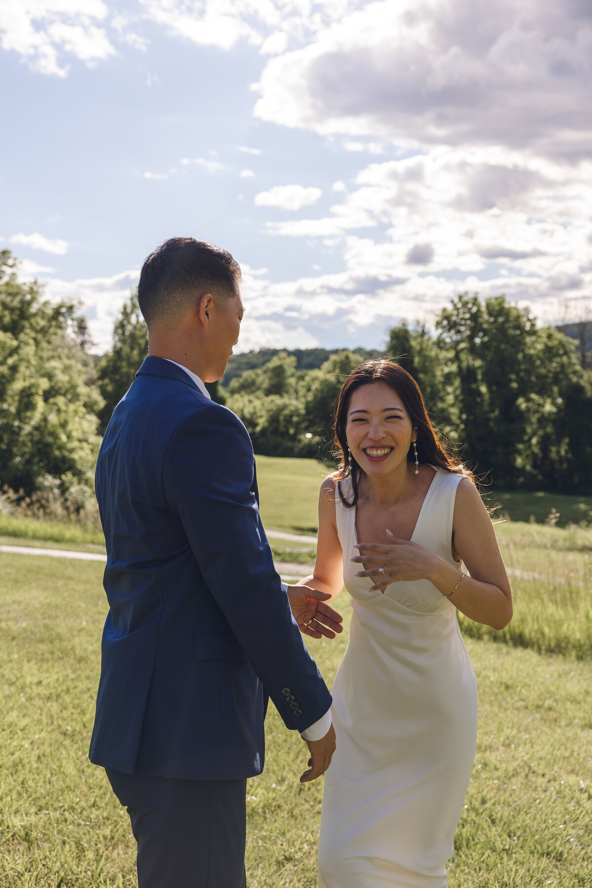 Bride laughing while hugging groom during golden hour portraits