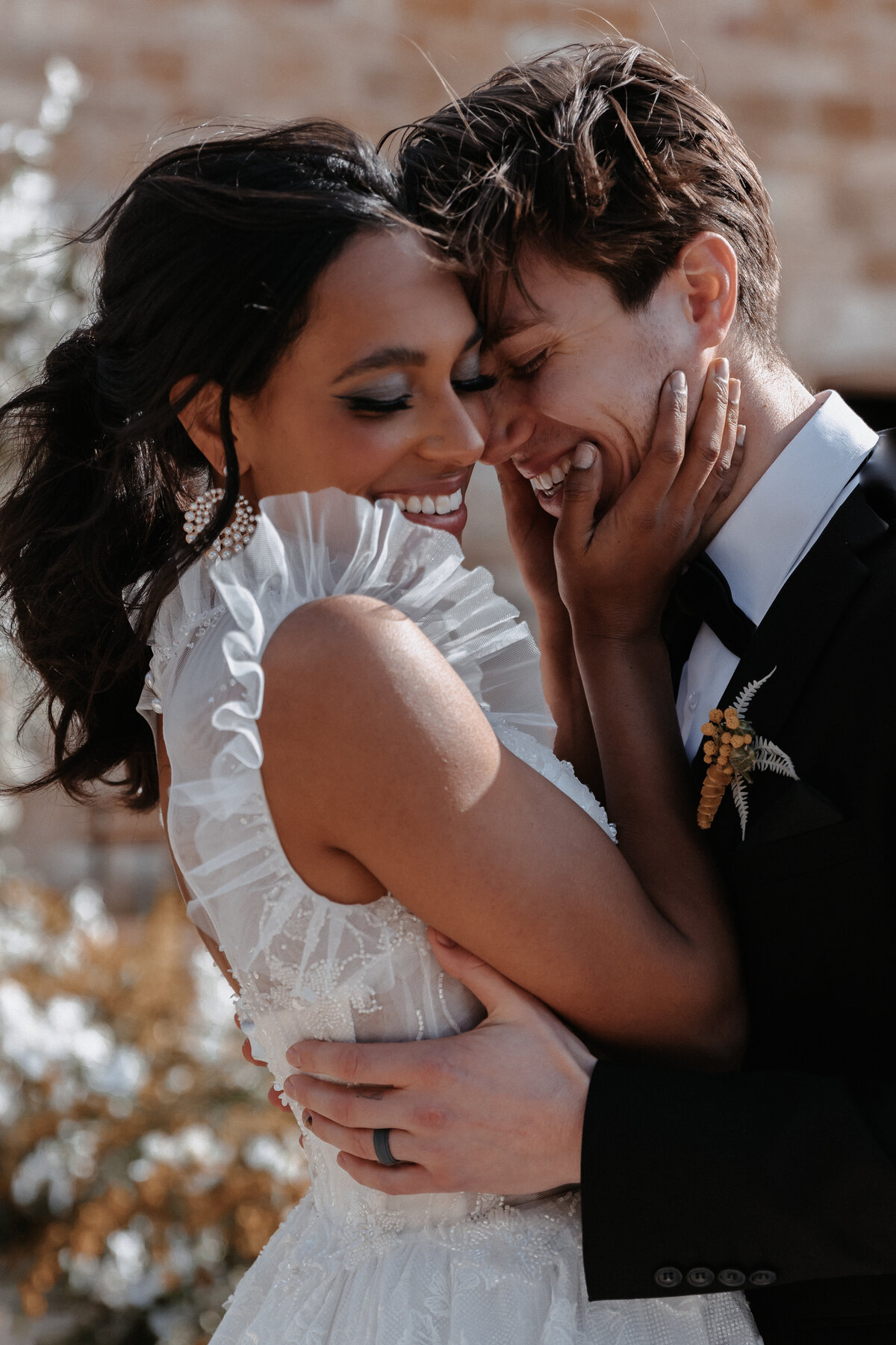 Close-up of bride and groom sharing an intimate moment, with white and gold floral details in the background at Sunstone Winery.