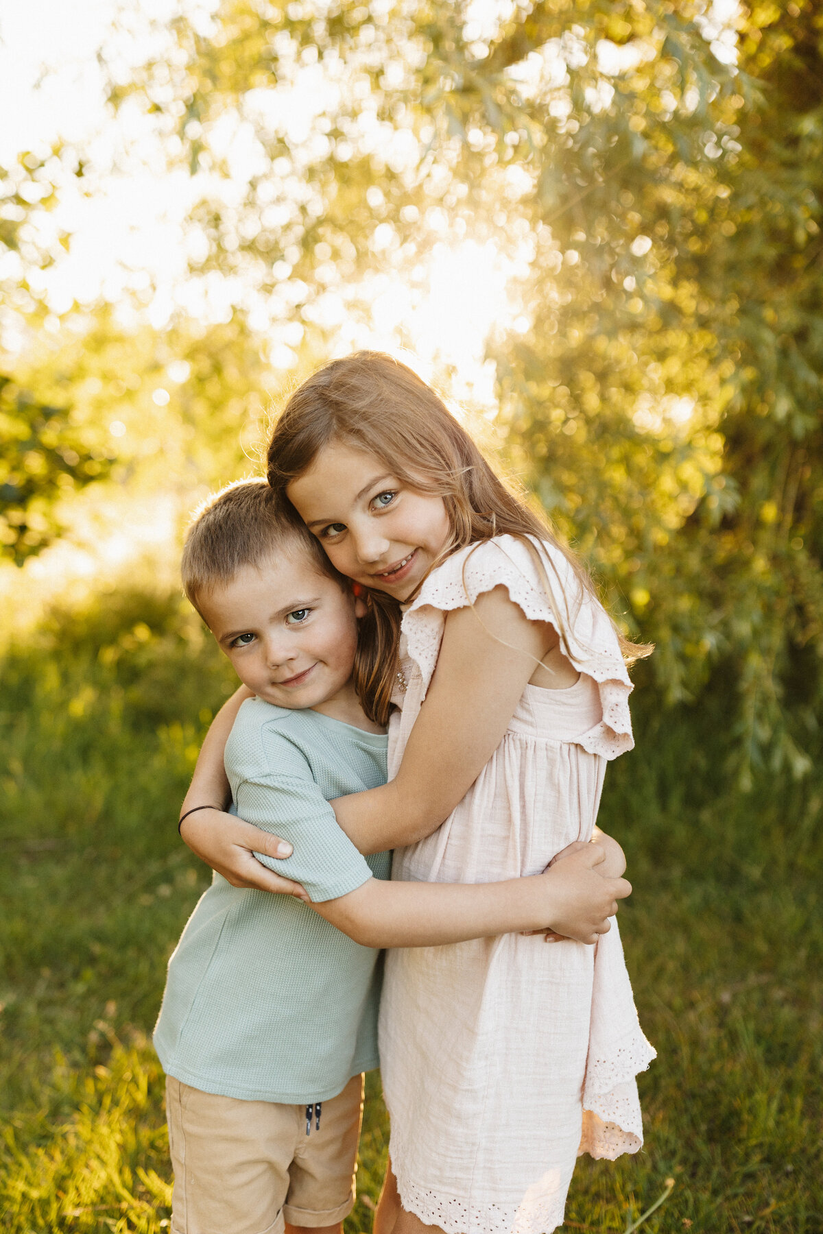 A brother and sister hugging during their family portrait photoshoot while they're photographed by Christchurch photographer Lucy Jane Photography