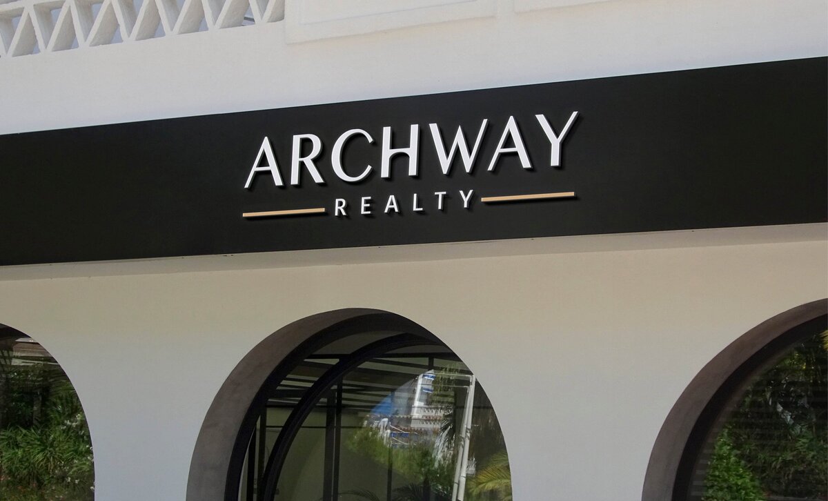 Modern black-and-white exterior signage with the Archway Realty logo displayed on an arched building facade.