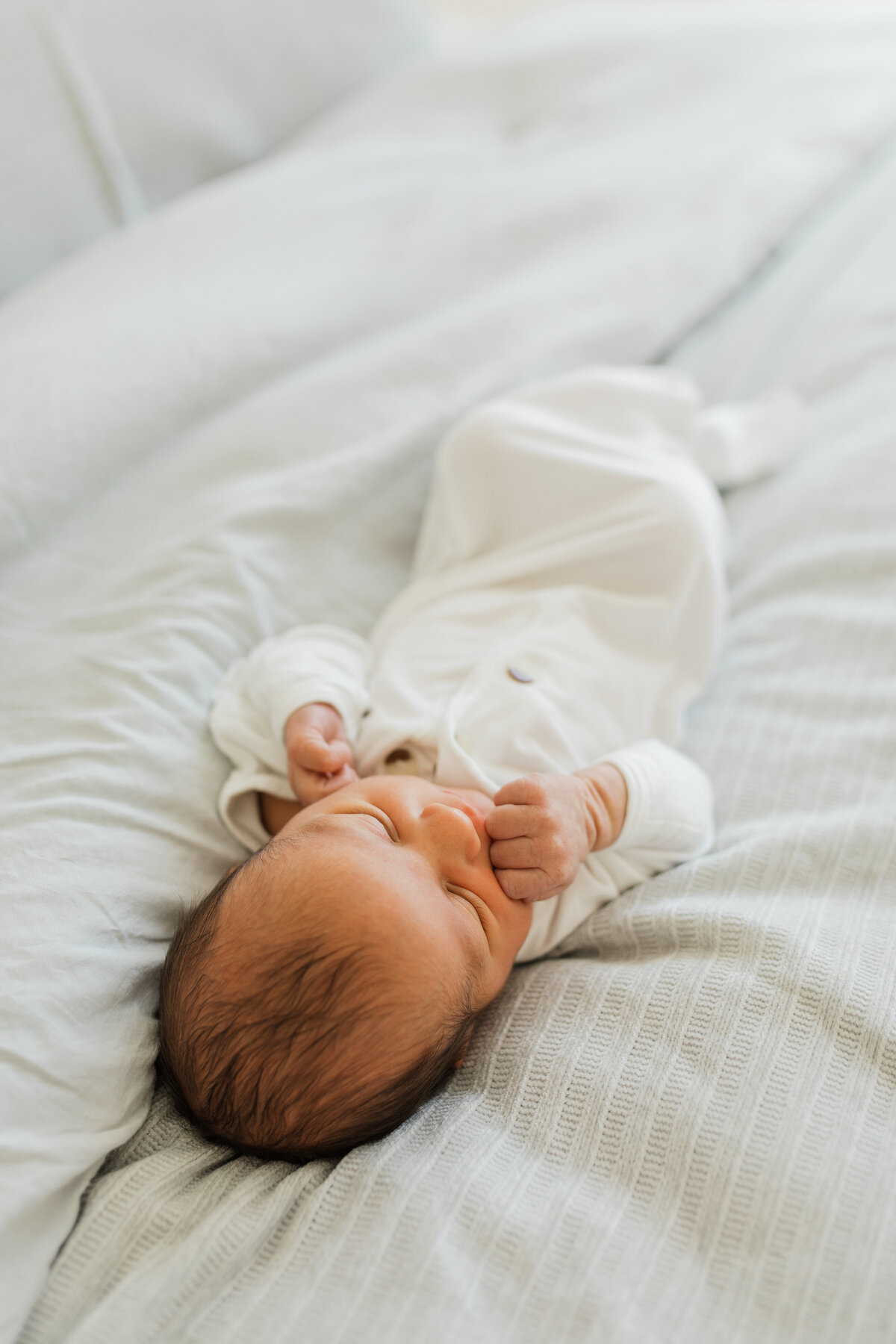 close up of a newborn sucking her hand