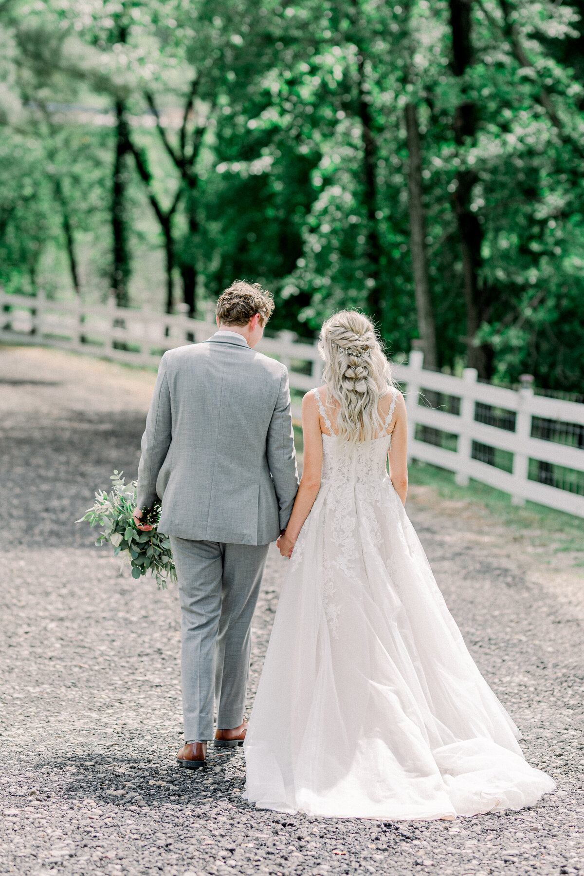 Bride and groom walking back down the road hand in hand