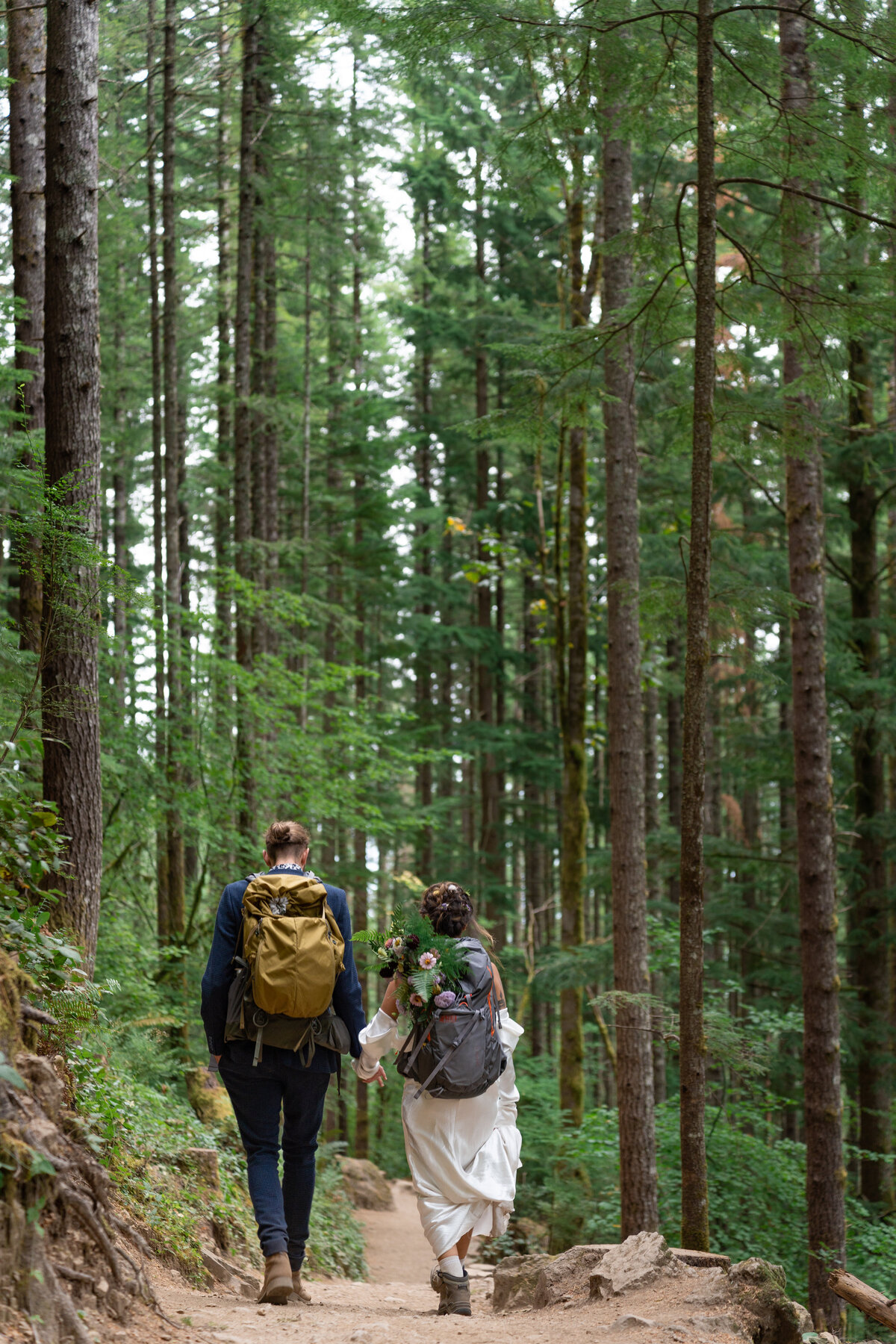An elopement couple hiking with backpacks on
