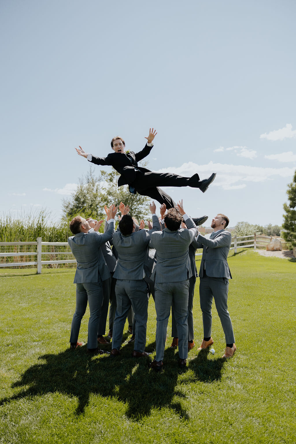 Groomsmen tossing the groom in the air