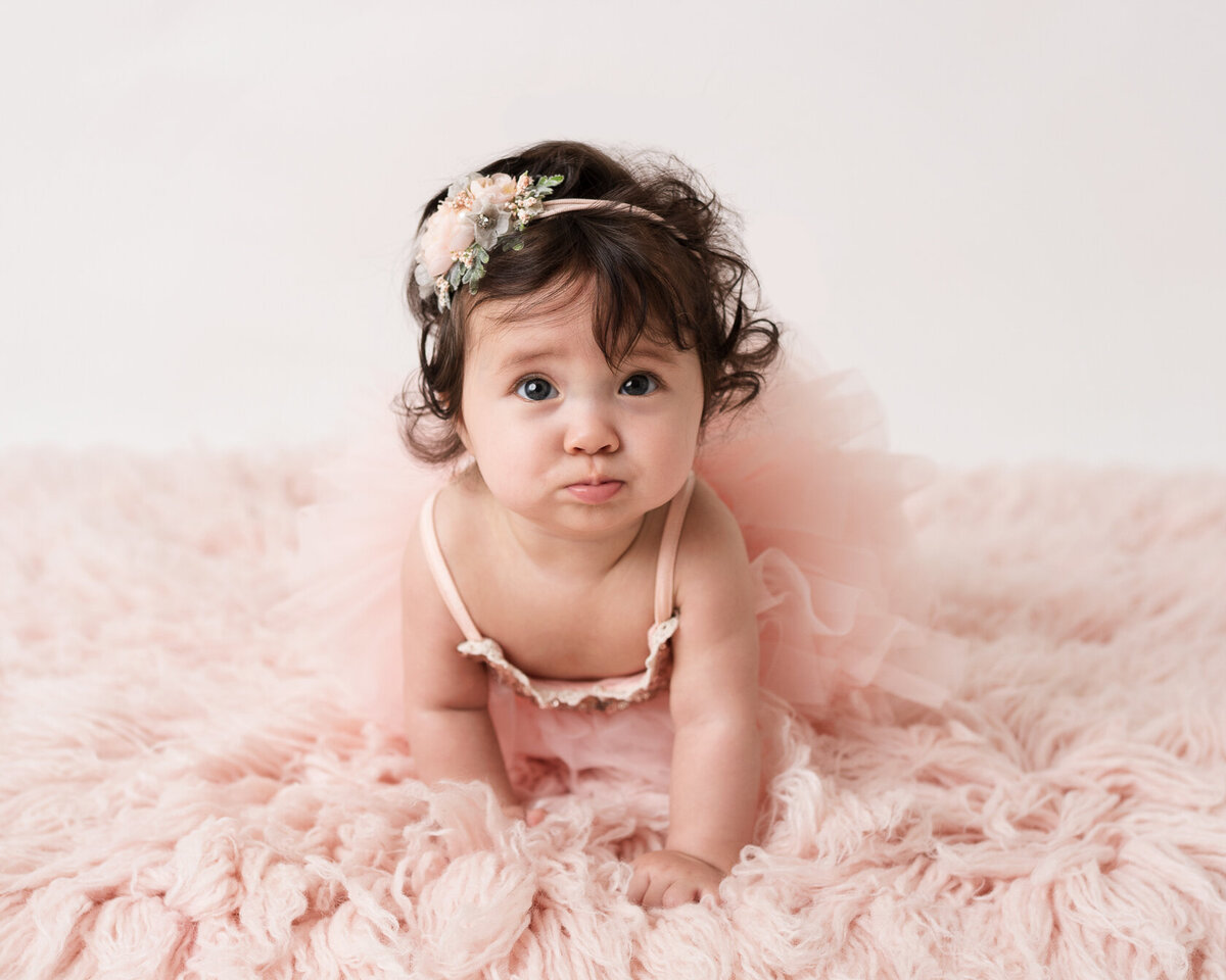 Cute little baby in a pink furry background by Laura King Photography