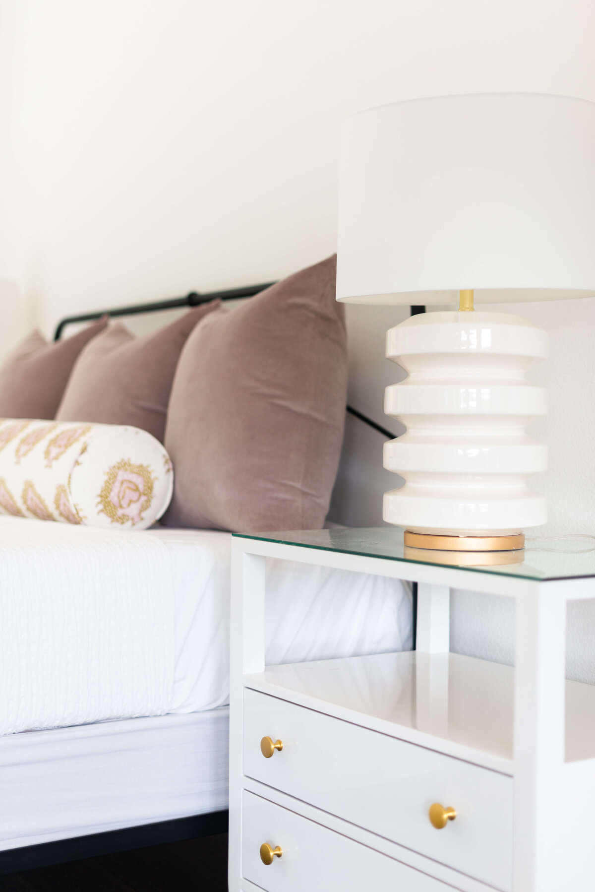 oyster creek studios building belt new build white bed with taupe pillows next to white side table with lamp