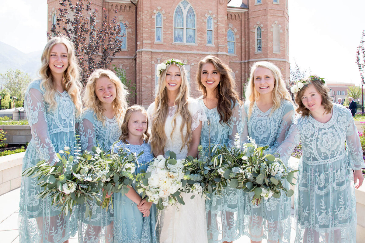 bride and bridesmaids in mint dresses holding bouquets posing for a group wedding portrait