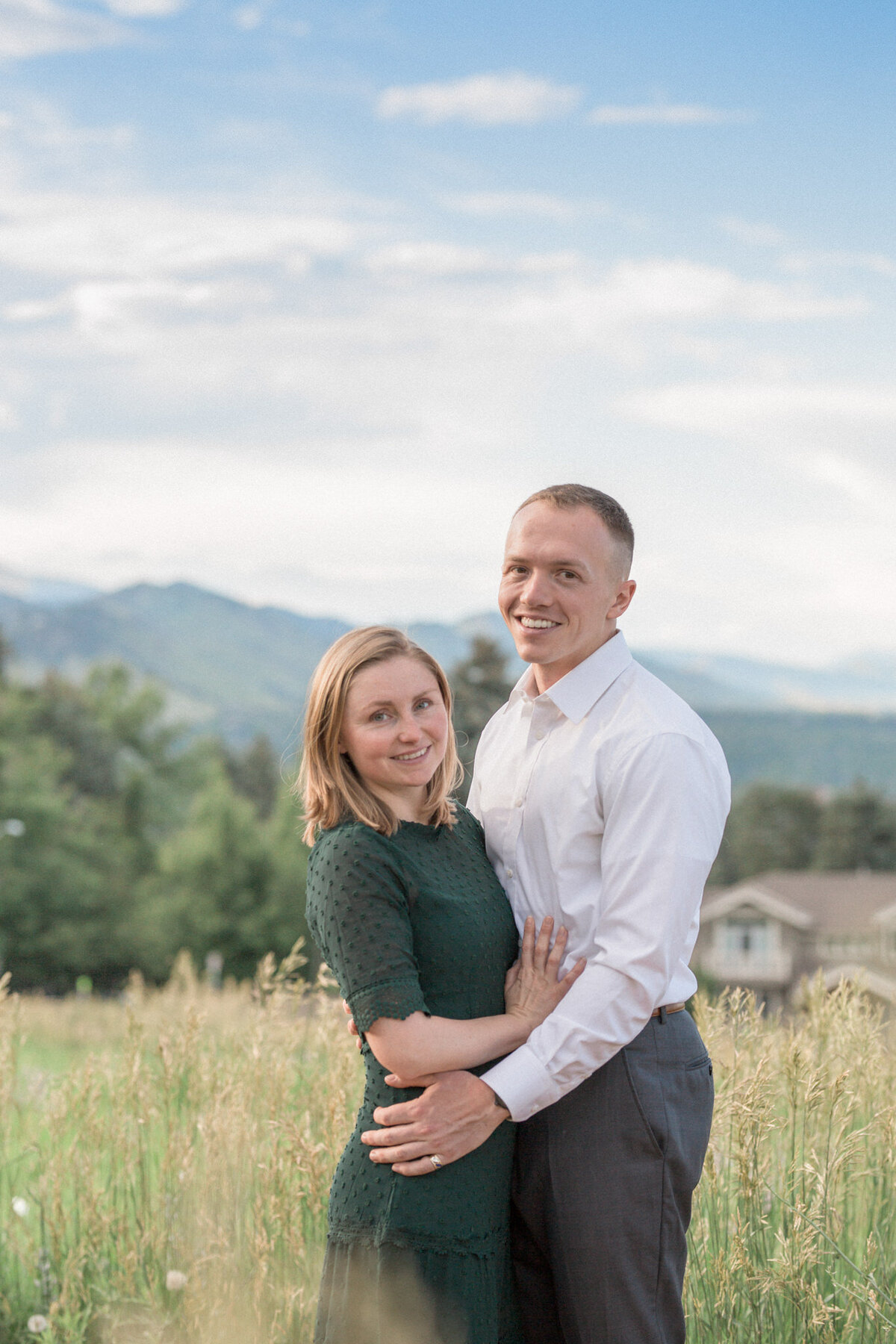 A couple poses in front of the Boulder Foothills during their engagement session at Chautauqua Park in Boulder
