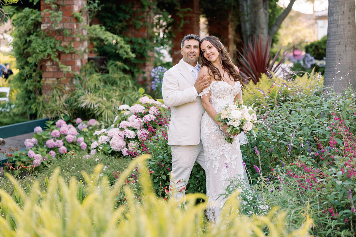 A newlywed couple standing close together smiling