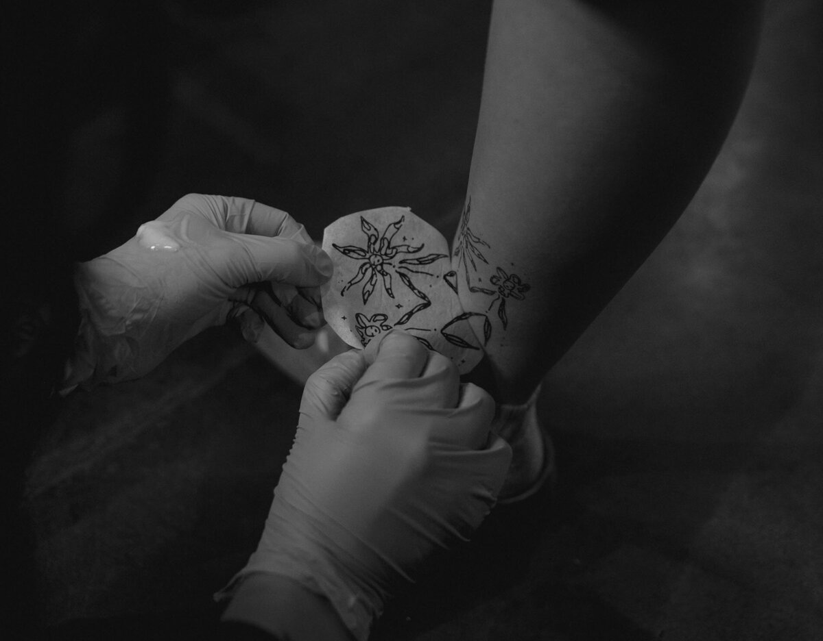 tattoo artist peels off transfer paper revealing tattoo in Bend, Oregon studio