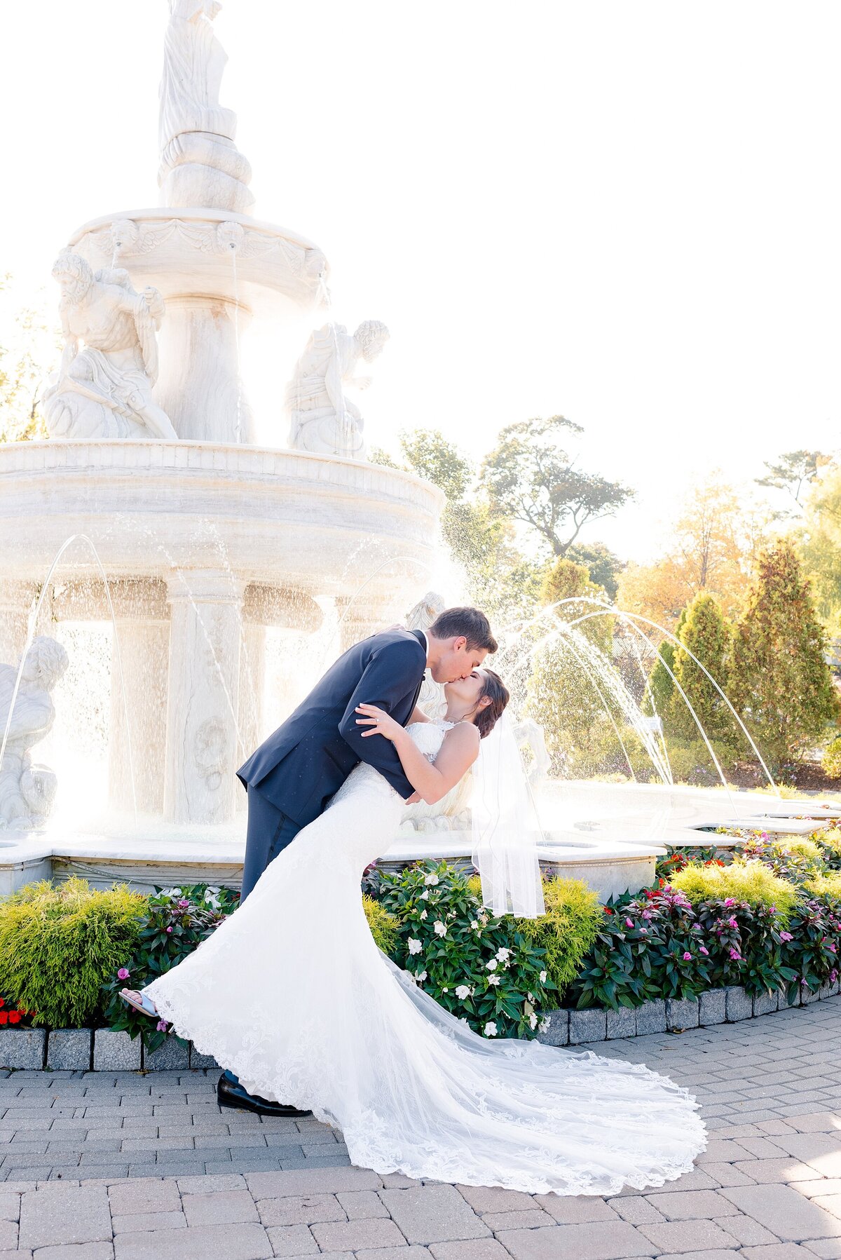 16_groom-dips-bride-in-front-of-The-Surf-Club-on-the-Sound-fountain_4067