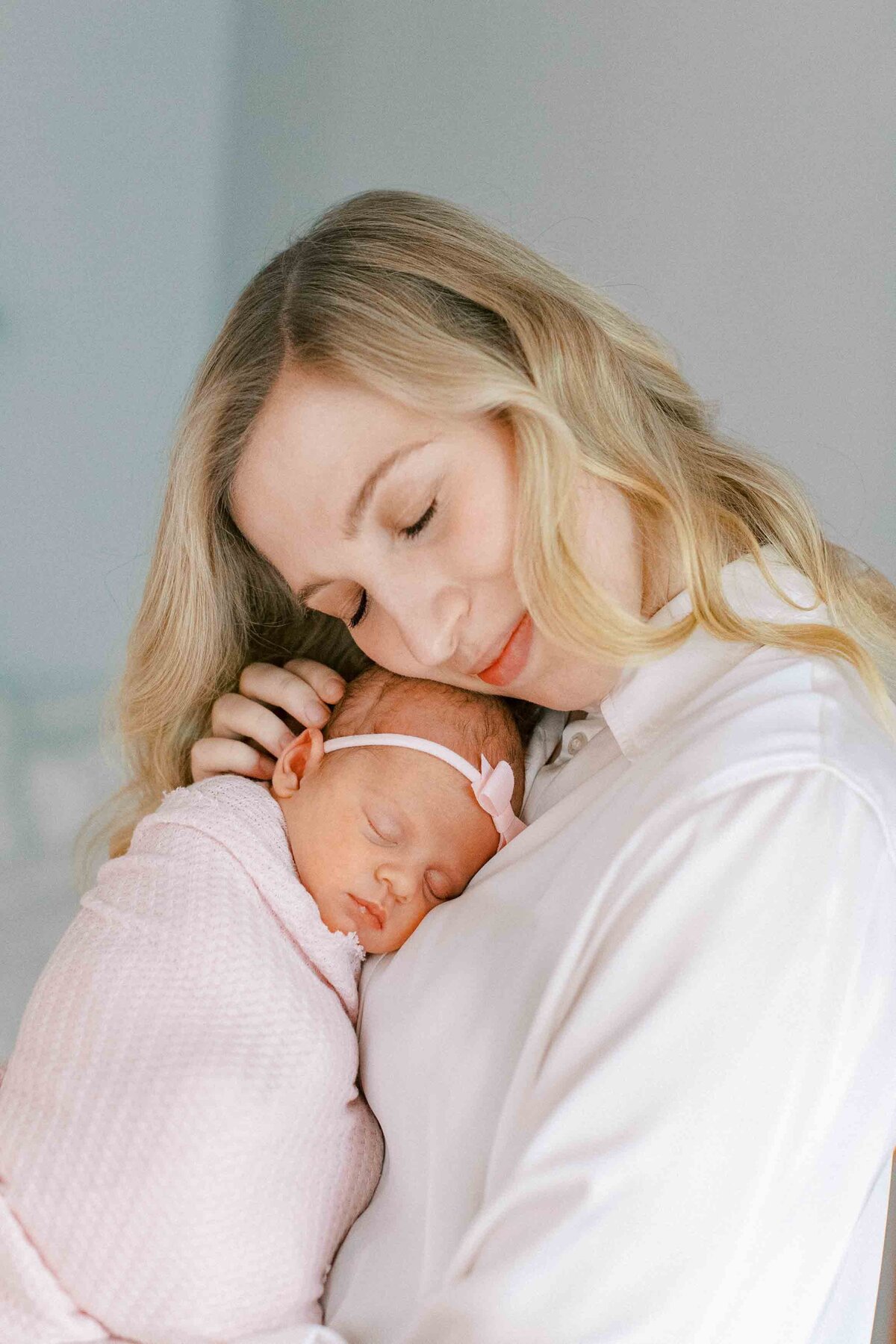 mom snuggling her baby and closing her eyes