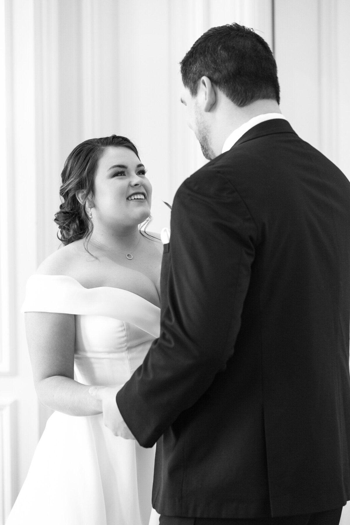 black and white photo of the bride’s reaction during the first look as they hold hands in the Governor’s Room at The Adolphus in Dallas, capturing an intimate and heartfelt wedding moment.