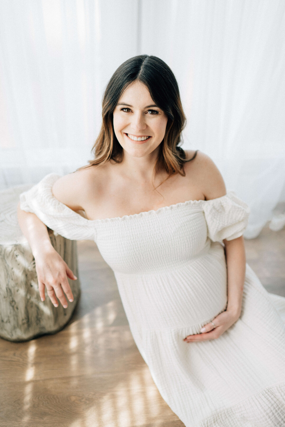 maternity mother holding he belly and smiling at Denver photographer