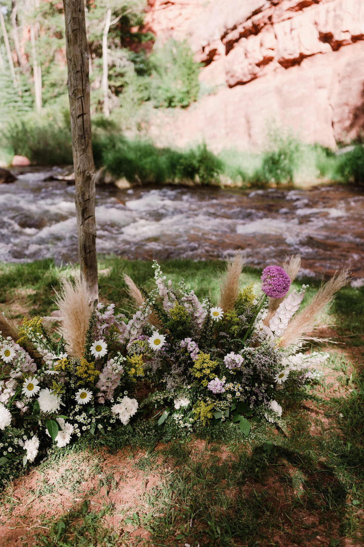 White, pink, yellow floral arrangements with pampas grass
