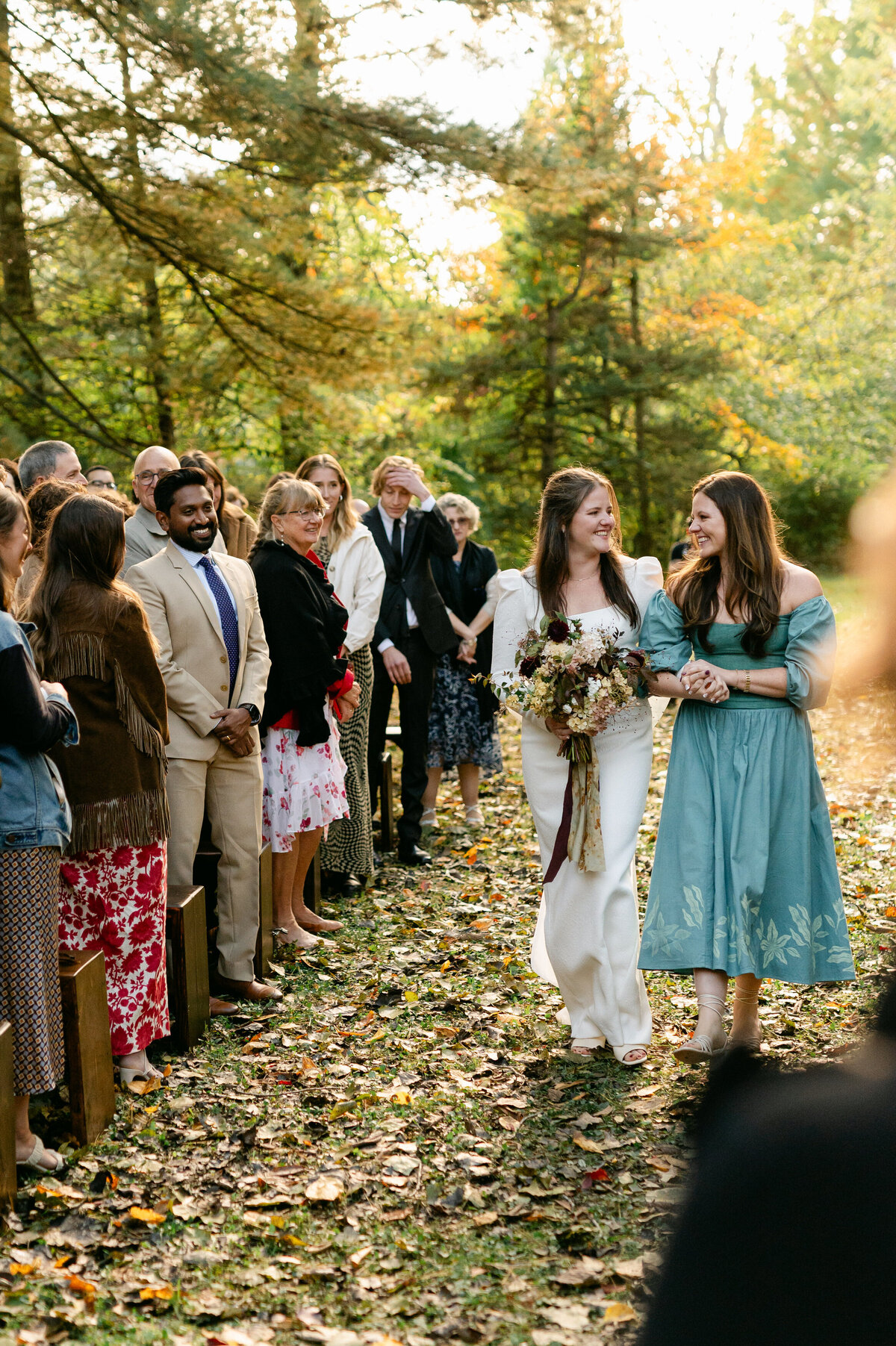 Bride walking down the aisle with women hand in hand