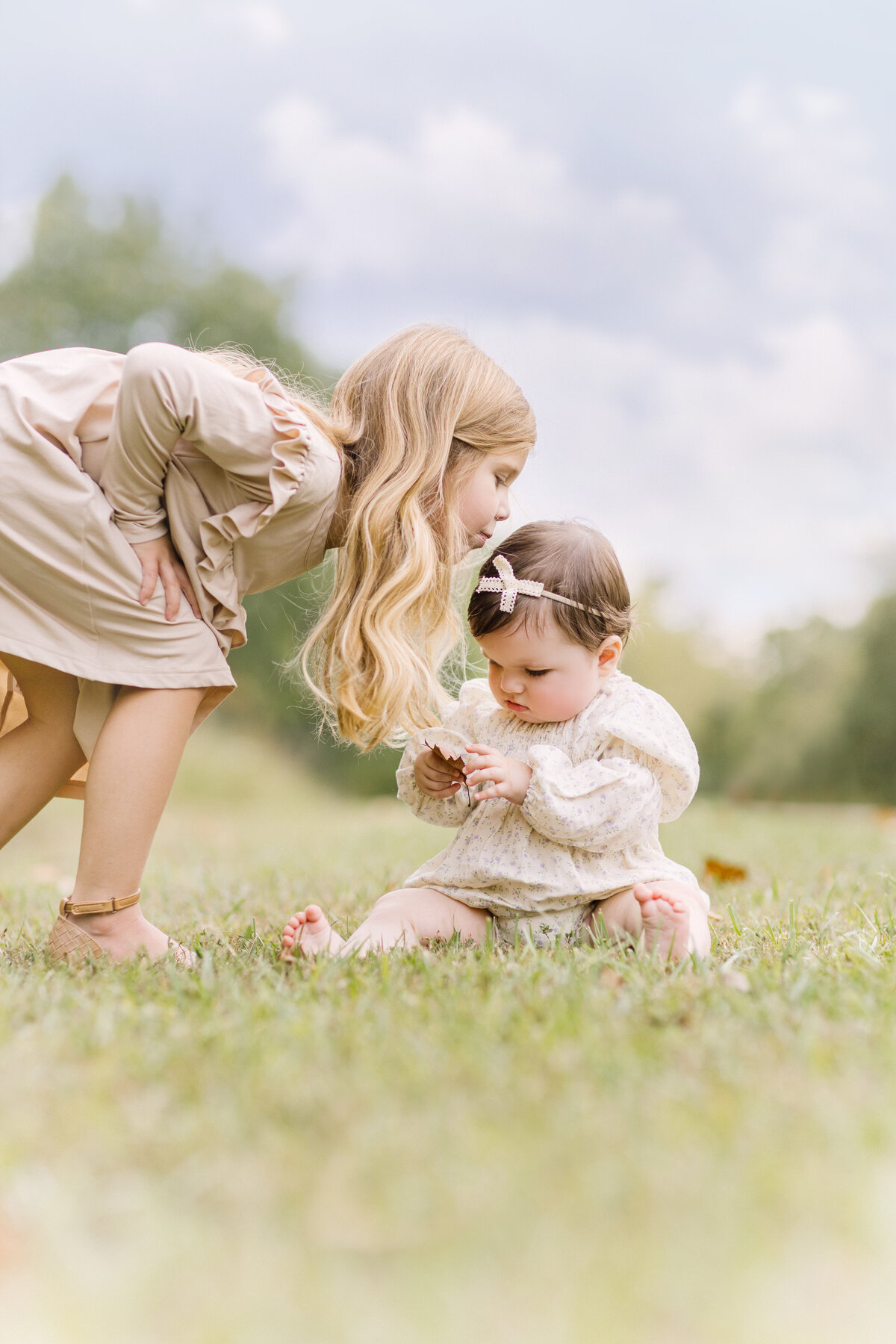 Mother wearing a floral hijab and blue dress holding her baby daughter